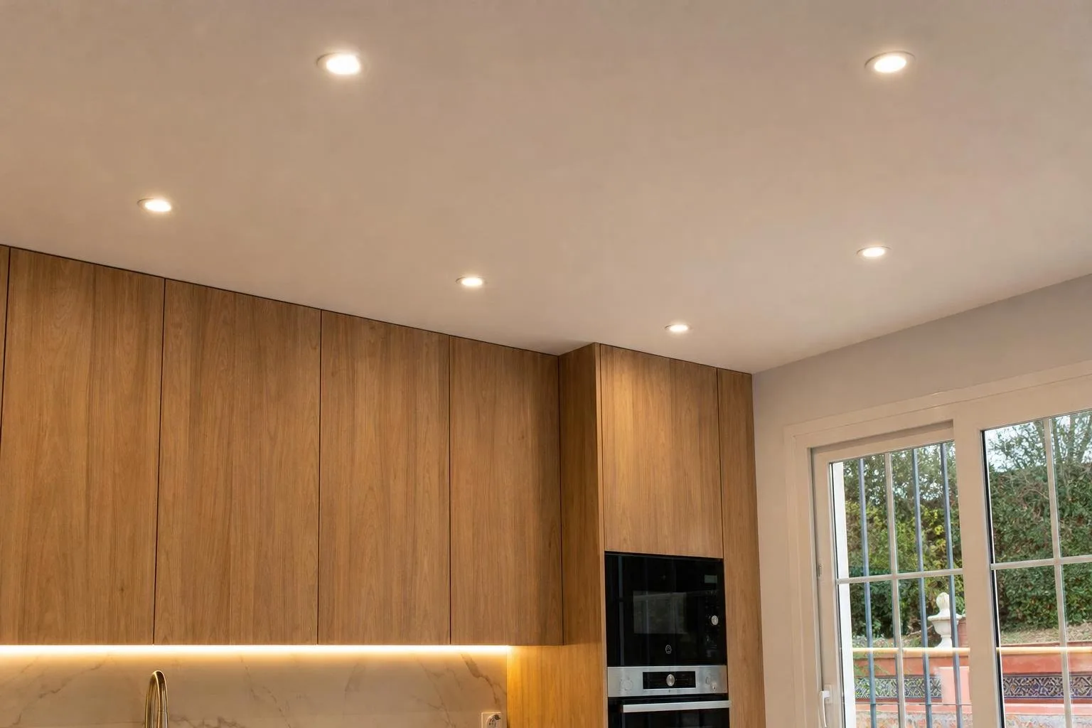 Focos LED empotrados encendidos en el techo de una cocina