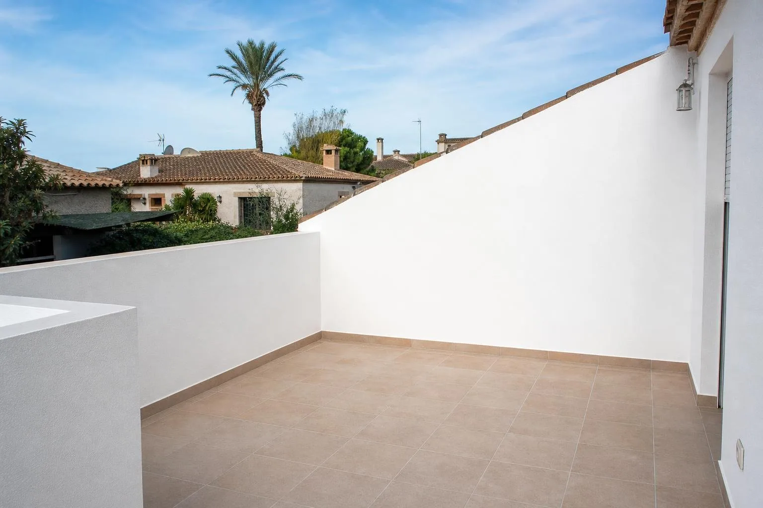 Pared de terraza enfoscada y pintada de blanco